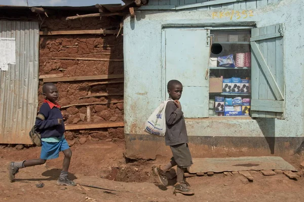 Chicos pasan por el quiosco con condones en escaparate en una calle de Kibera, Nairobi, Kenia . — Foto de Stock