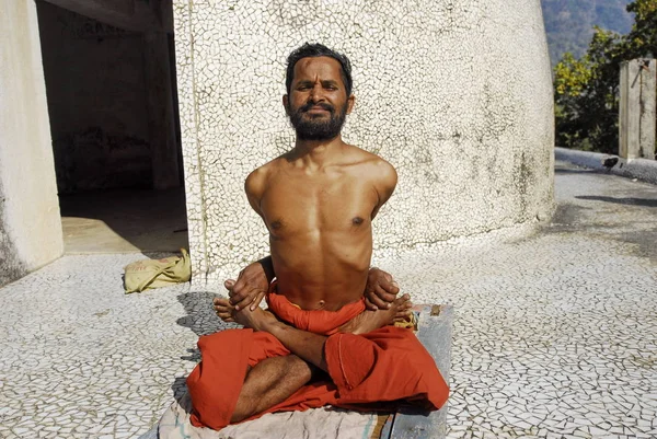 Indian sadhu hace ejercicios de yoga en Maharishi Ashram, Rishikesh, India . — Foto de Stock