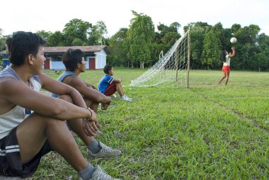 Bora men watch soccer match between local women in Padre Cocha, Iquitos, Peru.  clipart