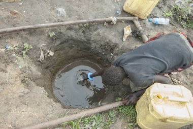 Kadın kirli delik mülteci kampı, Juba, Güney Sudan içme suyu alır.