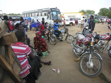 JUBA, SOUTH SUDAN, FEBRUARY 27, 2012: Unidentified people wait for their buses at a bus station of Juba, South Sudan. There are international bus routs from Juba to Nairobi and Kampala . clipart