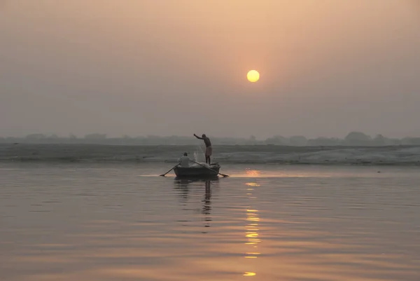 Fishermen silhouettes on sunrise background, The Ganges River, Varanasi, India.