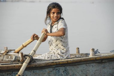 Varanasi, Hindistan, 30 Nisan 2009: Tanımlanamayan Hintli kız Hindistan'da Varanasi, Ganj Nehri üzerinde tekne ederek. Varanasi tüm çocukları erken yaşta tekne kürek kullanmak mümkündür.