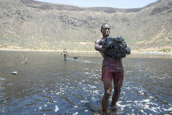 Sod 埃塞俄比亚 2012年3月8日 不明身份的 Borana 人携带巨大的一块盐渍泥从火山口湖厄尔尼诺 埃塞俄比亚 Sod 的黑盐矿床由 Borana — 图库照片