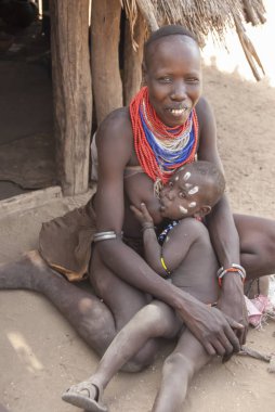 Colcho, Etiyopya, 15 Mart 2012: Tanımlanamayan Karo kadın Colcho, Omo Vadisi, Etiyopya çocuğunu emzirir. Çocuk yetiştirme Karo kabilesinin bütün kadınlar için bir görevidir.