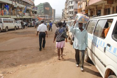 Kampala, Uganda, 23 Şubat 2012: Kimliği belirsiz Kampala, Uganda bir sokakta kafasına eşyalarını taşır. Kafasına taşıyan hem erkek hem de kadın Uganda için yaygın bir uygulama olduğunu.
