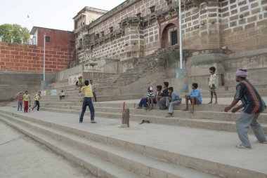 VARANASI, INDIA, APRIL 28, 2009: Hindistan 'ın Varanasi kentindeki Ganj Nehri yakınlarındaki ghat üzerinde tanımlanamayan Hintliler kriket oynuyor. Kriket Hindistan 'daki en popüler takım sporudur..