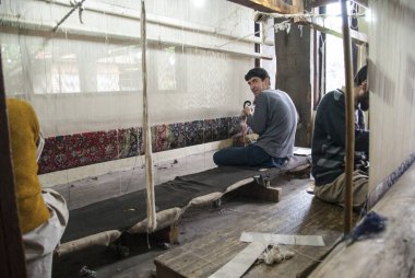 SRINAGAR, INDIA, 5 Mayıs 2009: Kimliği belirsiz bir adam Hindistan, Srinagar 'da bir halı dokuyor. Geleneksel Kashmiri el yapımı halılar eski çağlardan beri oldukça değerlidir..