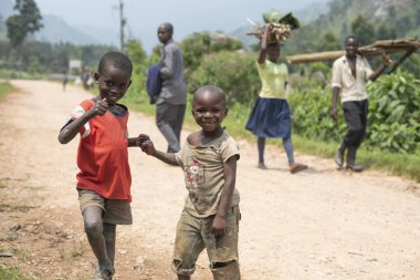 BUGOYE, UGANDA, 21 HAZİRAN 2020: Tanımlanamayan çocuklar Uganda 'nın Bugoye köyünün bir caddesinde poz veriyorlar. Kırsal kesimdeki çocuklar okulda çalışmak yerine kendi başlarının çaresine bakmak zorundalar..