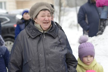 MOSCOW, RUSSIA, 17 Şubat 2018: Kimliği belirsiz yaşlı kadın ve küçük kız, Moskova, Rusya 'da düzenlenen Maslenitsa festivalinde eğleniyor. Bu çok popüler bir festival ve eğlenceli bir açık hava aktivitesi var..