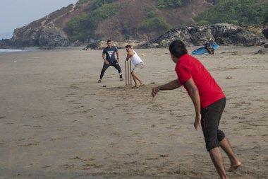 VAGATOR, Hindistan, 3 Şubat 2020: Kimliği belirsiz Hintli erkekler Goa, Hindistan 'da Vagator plajında kriket oynuyorlar. Kriket Hindistan 'daki en popüler takım sporudur..