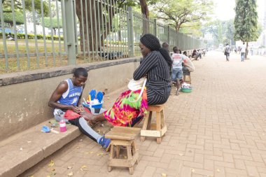 KAMPALA, UGANDA, 26 HAZİRAN 2020: Tanımlanamayan kadın Uganda, Kampala 'da bir sokakta pedikür yaptırıyor. Kampala şehrinde her türlü güzellik hizmetine erişilebilir..