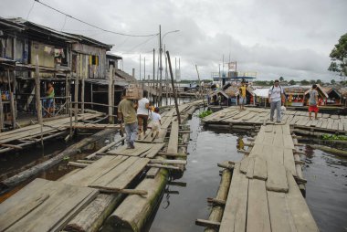 IQUITOS, PERU, APRIL 28, 2010: Iquitos, Peru 'daki küçük tekneler için Nanay iskelesi. Tekneler uzak köyleri Iquitos 'a bağlamak için tek ulaşım biçimidir..