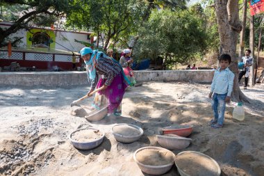 CANDOLIM, INDIA, FEBRUARY 6, 2020: Kimliği belirsiz kadın Candolim, Goa, Hindistan 'da inşaat için kum hazırlıyor. Hindistan 'da kadınlar için ağır işler hala yaygın olarak kullanılır..