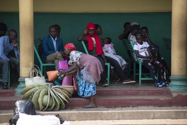 2020年1月25日 不明身份的妇女在乌干达穆本德市的汽车站为乘客出售柳条草帽和袋子 小企业往往只是当地人的财源 — 图库照片