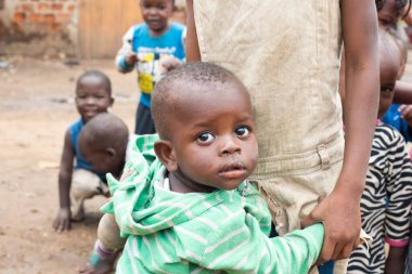 KAMPALA, UGANDA, JANUARY 26, 2020: Kimliği belirsiz küçük çocuk kız kardeşinin ellerini tutuyor, Katanga gecekondu mahallesi, Kampala, Uganda. Katanga 'daki en küçük çocuklar genellikle büyük kardeşlerinin denetimi altındadır..