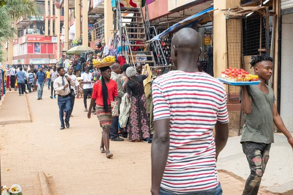 2020年1月12日 乌干达坎帕拉 一名身份不明的年轻女子头顶着装有香蕉的盘子走在一条街道上 对乌干达街头摊贩来说 头脑发热是一种常见的做法 — 图库照片