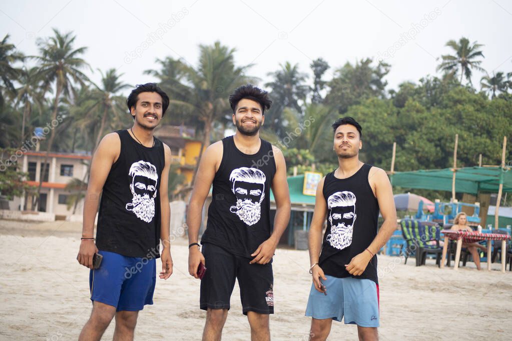 ARAMBOL, INDIA, FEBRUARY 20, 2020: Unidentified Indian men pose for photo in Arambol, Goa, India. For many Indian tourists Goa is state with many opportunities to spend a vacation.