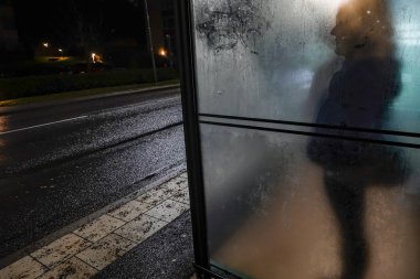 Stockholm, İsveç Lidingo 'da bir kadın otobüs durağında tek başına bekliyor..