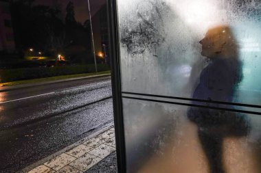Stockholm, İsveç Lidingo 'da bir kadın otobüs durağında tek başına bekliyor..