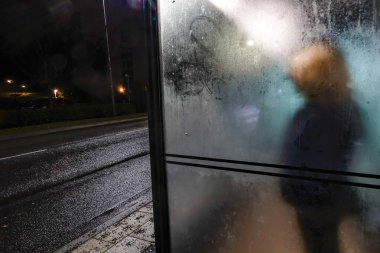 Stockholm, İsveç Lidingo 'da bir kadın otobüs durağında tek başına bekliyor..