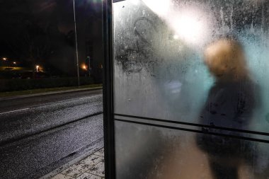 Stockholm, İsveç Lidingo 'da bir kadın otobüs durağında tek başına bekliyor..