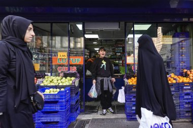İstanbul ve Türkiye 'de Balat mahallesindeki bir pazarın önünde peçeli kadınlar duruyor.