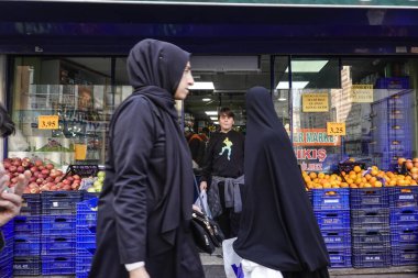 İstanbul ve Türkiye 'de Balat mahallesindeki bir pazarın önünde peçeli kadınlar duruyor.