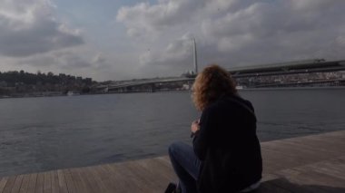 İstanbul, Türkiye Su kenarında bir turist oturuyor