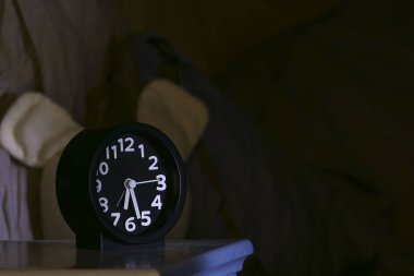 Bir komodindeki çalar saat ve bir oyuncak ayı..