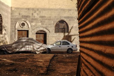 Cairo, Egypt A back alley in the  Khan el-Khalili bazaar and a covered car.