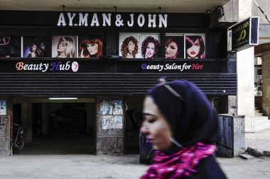 Kahire, Mısır modern Mısırlı bir kadın Dokki mahallesindeki bir güzellik salonunun önünden geçiyor..