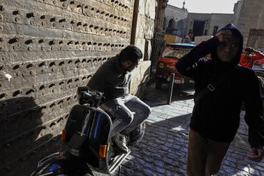 Kahire, Mısır. Meşgul Khan el-Khalili pazarının girişinde bir adam scooter 'da oturuyor.