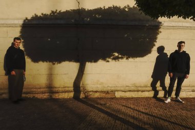 Kahire, Mısır İki genç adam gölgeli bir tütsü ağacının önünde duruyor.