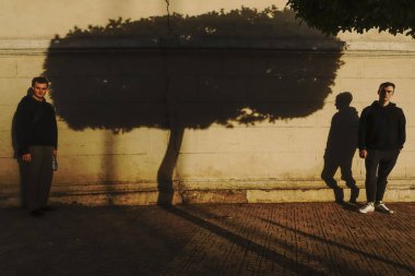 Kahire, Mısır İki genç adam gölgeli bir tütsü ağacının önünde duruyor.