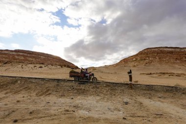 Siwa Oasis, Mısır Çölde bir motosiklet sürüyor.