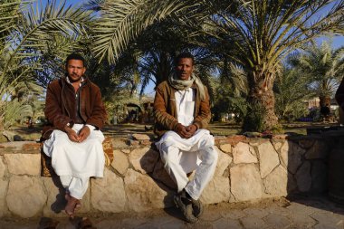 Siwa Oasis, Mısır Duvarda oturan iki yerli adam.