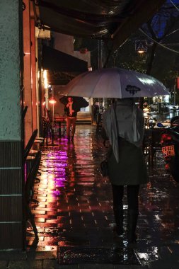 Tel Aviv, Israel People walking in the rain and reflections.