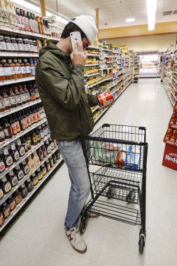 Boston, Massachusetts, A young man shopping while talking on the phone.