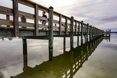Solomons, Maryland, Usa Patuxent nehrinde gün batımında yürüyen bir kadın..