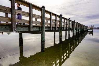 Solomons, Maryland, Usa Patuxent nehrinde gün batımında yürüyen bir kadın..