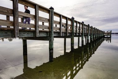 Solomons, Maryland, Usa Patuxent nehrinde gün batımında yürüyen bir kadın..