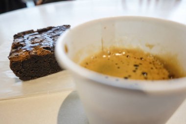 Kağıt bardakta bir fincan espresso ve çikolatalı brownie..