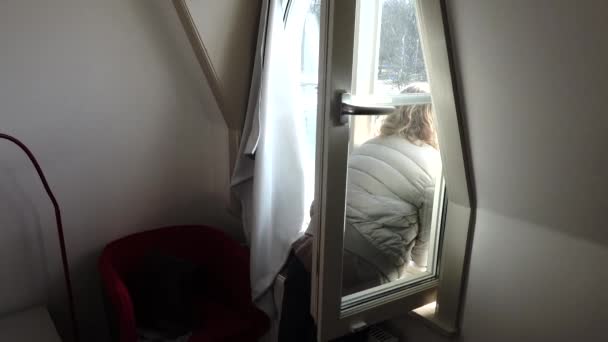 ノルトラジェ スウェーデン女性は彼女の部屋から窓の外を見る — ストック動画