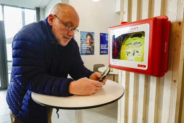 Стокгольм Швеция Марта 2020 Мужчина Проверяет Свой Телефон Рядом Дефрибиллятором — стоковое фото