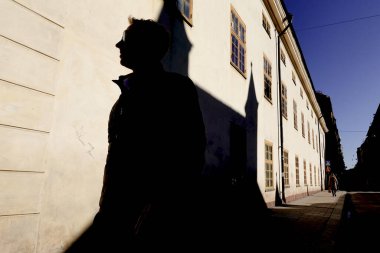 Stockholm, İsveç 7 Mart 2020 'de Riddargatan' daki yayalar Ostermalm 'da taretleri olan bir binanın gölgesinden geçtiler..