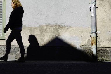 Stockholm, İsveçli yayalar ve şehir sokaklarında güçlü bir gölge.