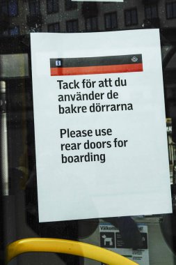 Stockholm, İsveç Şehir Otobüsündeki bir tabelada, lütfen kirlenmeyi önlemek için İsveççe ve İngilizce giriş için arka kapıyı kullanın, diyor..