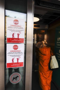 Stockholm, İsveç 'te bir binadaki işaret insanları korona virüsü hakkında uyarıyor, İsveççe.