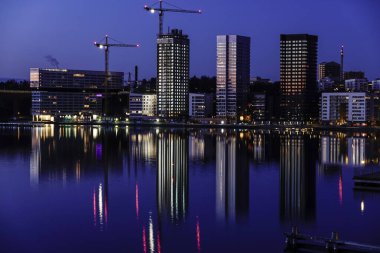 Stockholm, İsveç Liljeholmskajen 'in sularındaki kulelerin yansımaları.